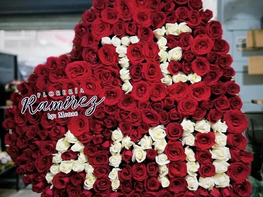 Arreglo de corazón con rosas rojas y «Te amo» en rosas blancas